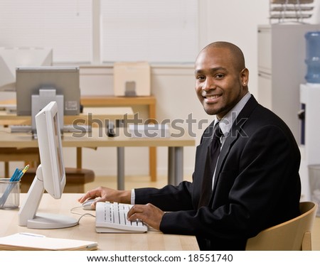Confident businessman typing on computer at desk