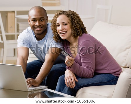 Happy couple using credit card to shop online conveniently