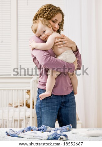 Devoted mother hugging and comforting her son in bedroom