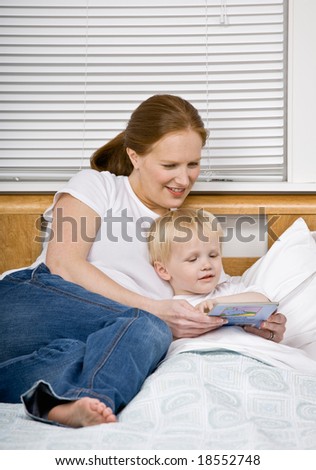 Devoted mother reading son a bedtime story in bed
