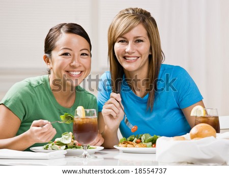 Happy friends eating healthy lunch and smiling