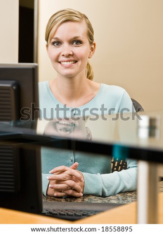 Friendly receptionist posing at front desk