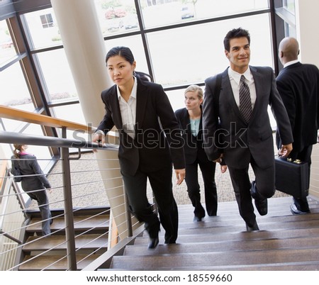 Multi-ethnic co-workers ascending and descending office stairs