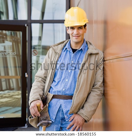 Male construction worker posing in hard-hat and tool belt