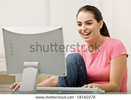 Happy woman typing on computer