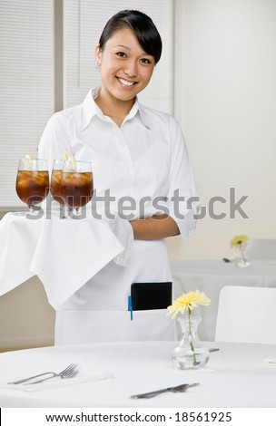 Happy waitress serving iced tea in elegant restaurant