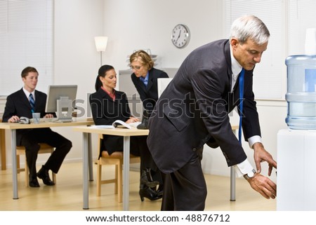 Businessman getting water from water cooler