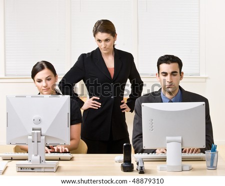 Businesswoman watching co-workers work
