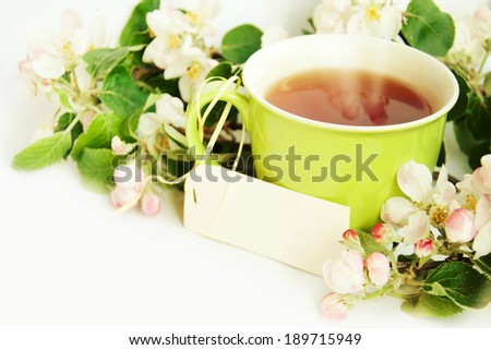 Cup of tea with card and apple blossom.