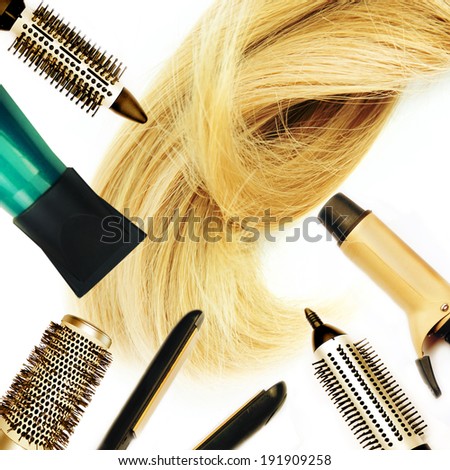 Comb brushes and hairdryer with blond hair.