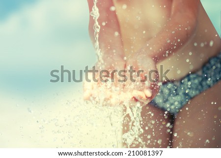 Stream of clean water pouring into children\'s hands.