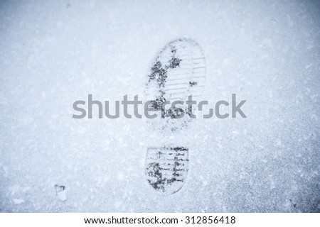 Footprint in fresh snow background great concept for winter footwear, Closeup