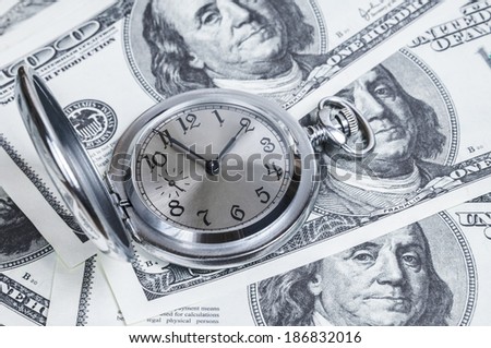 Vintage watches are laing on hundred dollar bills