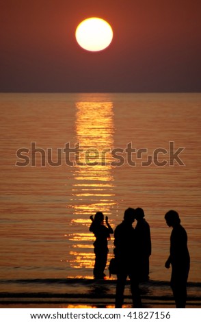 people on the beach in dusk