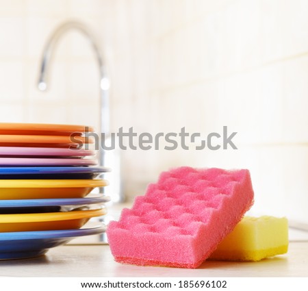 Several plates and a kitchen sponge. Dishwashing concept.