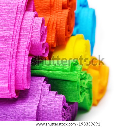 Rolls of various color paper on white background.