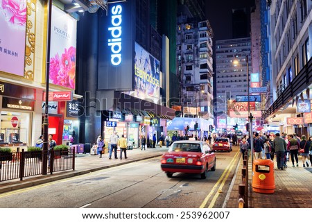 HONG KONG - JANUARY 31, 2015: Taxi and illuminated signs on the street of night city. Hong Kong is popular tourist destination of Asia and leading financial centre of the world