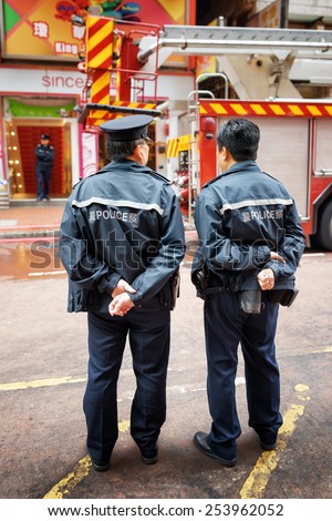 HONG KONG - FEBRUARY 1, 2015: Police officers providing order near the shopping mall where were caused by firefighters. Hong Kong is a leading financial centre of the world.