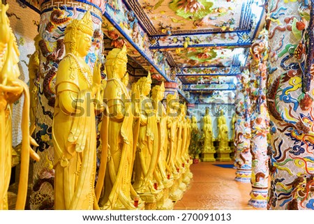 DA LAT, VIETNAM - MARCH 20, 2015: Golden Buddha statues along the wall in the interior of the Linh Phuoc Pagoda in Da Lat city (Dalat), Vietnam. Da Lat is a popular tourist destination of Asia.