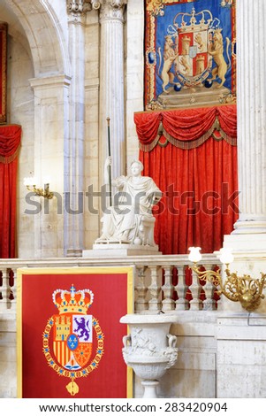 MADRID, SPAIN - AUGUST 18, 2014: The coat of arms of the King of Spain and a sculpture in the interior of the Royal Palace of Madrid in Spain. Madrid is a popular tourist destination of Europe.