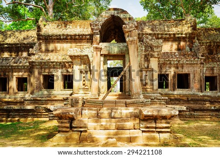 Mysterious Ta Kou Entrance (East Gate) in ancient temple complex Angkor Wat in Siem Reap, Cambodia. Woods and blue sky in background. Angkor Wat is a popular tourist attraction.