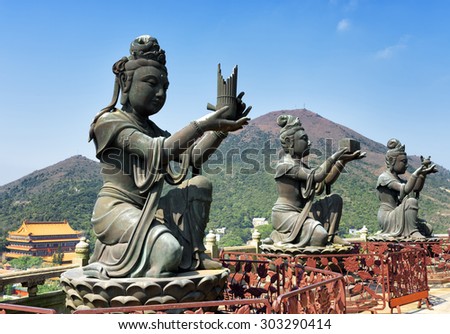 Buddhist statues praising and making offerings to the Tian Tan Buddha. The Po Lin Monastery and the Lantau Peak in the background, in Hong Kong. Hong Kong is popular tourist destination of Asia.