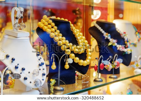 VENICE, ITALY - AUGUST 24, 2014: Original jewelry from Murano Glass in shop window on the Rialto Bridge. Beautiful beads, necklaces and earrings. Venice is a popular tourist destination of Europe.