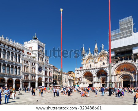 VENICE, ITALY - AUGUST 24, 2014: The Clock Tower and the Patriarchal Cathedral Basilica of Saint Mark (Basilica Cattedrale Patriarcale di San Marco) on the Piazza San Marco.
