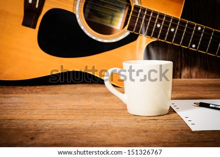 coffee cup and guitar on wooden table