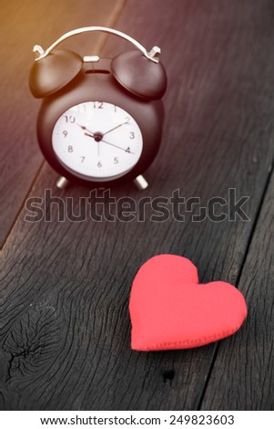 Vintage background with retro alarm clock on table , vintage filter effect