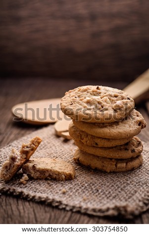 Chocolate cookies on white linen napkin on wooden table. Chocolate chip cookies shot on sack