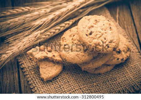 Chocolate cookies on white linen napkin on wooden table. Chocolate chip cookies shot on sack;vintage tone style