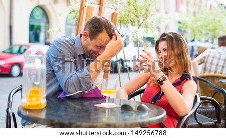 Young couple have a great time in cafe with mobile phone.