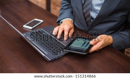 Hands of businessman with laptop,mobile phone and tablet.