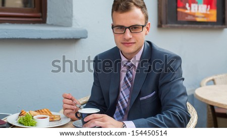 A close-up portrait of a businessman having breakfast.