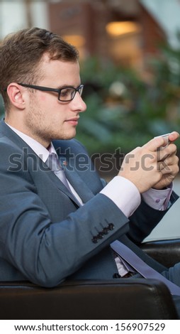 Young business man working with mobile phone, vertical portrait.