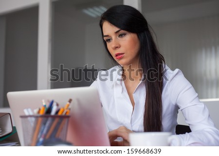 Beautiful secretary working in office with laptop computer.