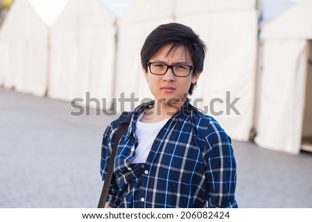 Asian man with glasses stand at street, closeup portrait