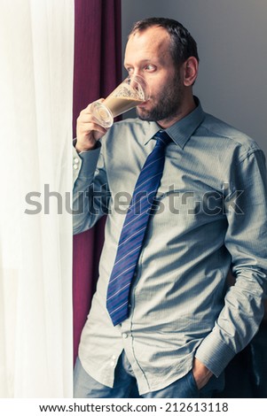 Businessman eating breakfast at home/hotel. Indoor photo