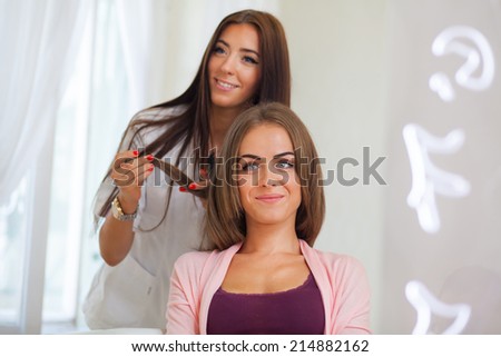 Hairdresser doing haircut for women in hairdressing salon. Concept of fashion and beauty. Positive emotion