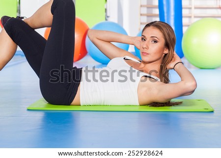 fitness, sport, training and lifestyle concept - woman stretching and doing physical exercises  on mat in gym.
