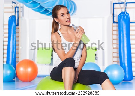 fitness, sport, training and lifestyle concept - woman stretching and doing physical exercises  on mat in gym.