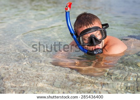 Boy swimming in the sea in mask, and fins.