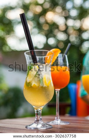 Cold, refreshing and colorful drinks with straws on wooden table.