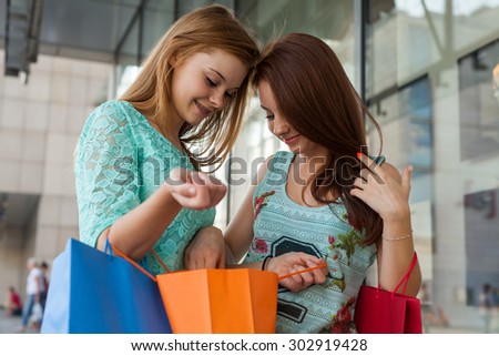 Young girls unpacking their shopping bags. Season of sales
