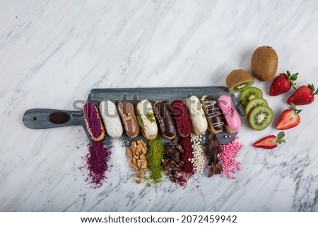 Prepared for special occasions, delicious and beautiful chocolate small cake ekler pastry. Ekler Pasta. Chocolate Donut with pistachio powder. Stok fotoğraf © 