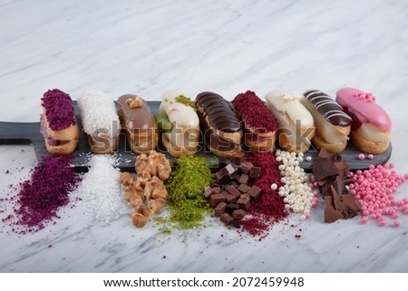 Prepared for special occasions, delicious and beautiful chocolate small cake ekler pastry. Ekler Pasta. Chocolate Donut with pistachio powder. Stok fotoğraf © 