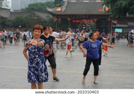CHENGDU, CHINA - JULY 5: Unidentified middle aged women dance at Wide and narrow Alley Square on July 5, 2014, Chengdu, Sichuan, China. Square dance is very popular in China.