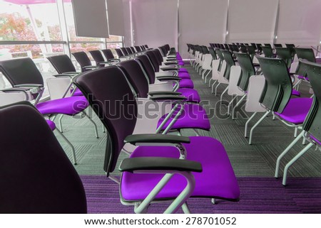 Many purple chairs arranged neatly in a training room.