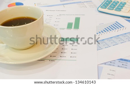 Cup of coffee and calculator on the document.